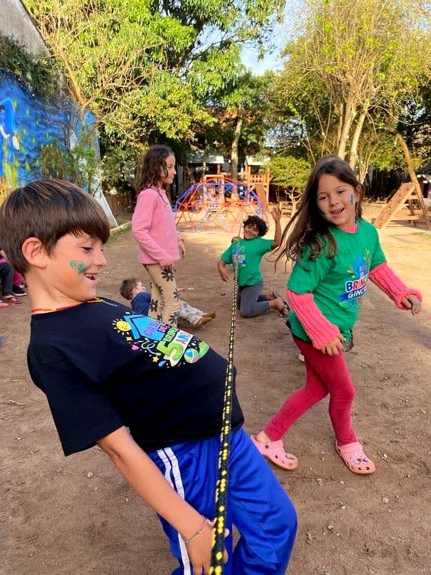 Crianças brincando de cabo de guerra no pátio da Casa de Brincar